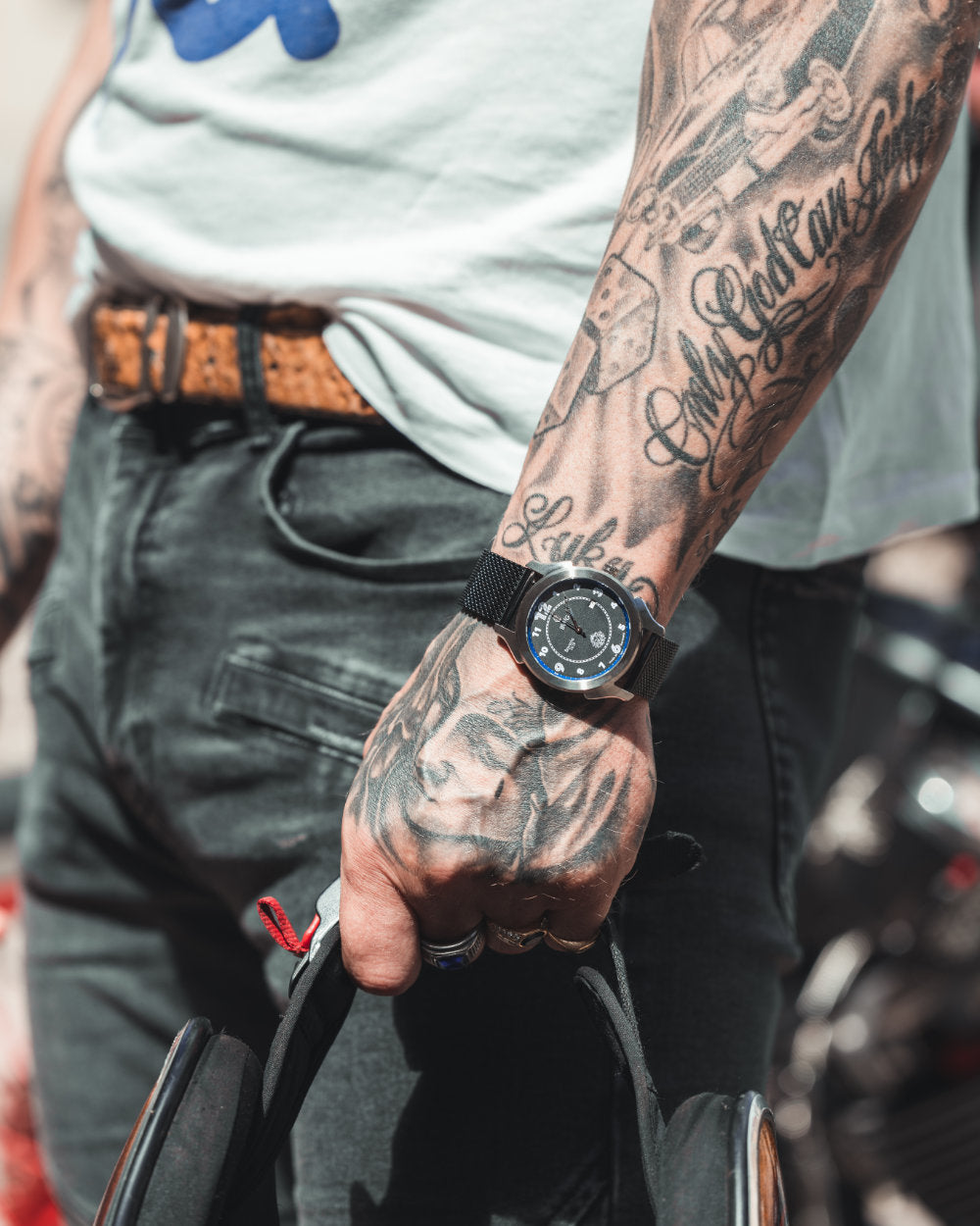 Man with tattooed hand wears a BWG Bavarian watch BAVARIA GOOD Design awarded Premium Quartz Watch with Swiss Ronda Movement driving a motor-cycle