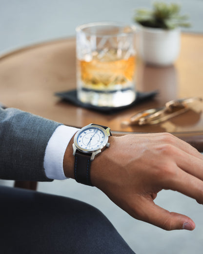 Man in suit sitting in front of a drink wearing a glacier white BWG Bavarian watch BAVARIA 