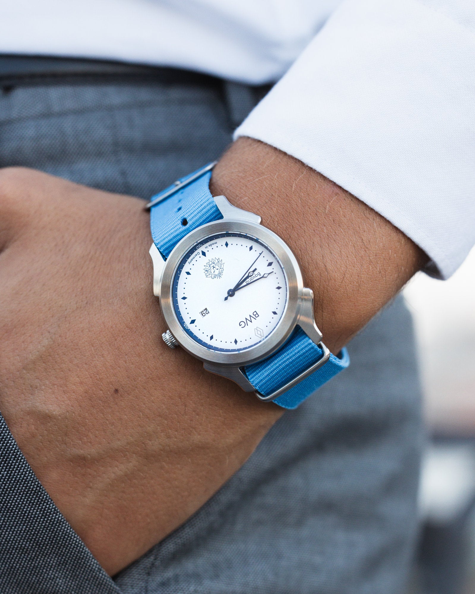 Man wears a BWG Bavarian Watch BAVARIA Glacier White premium quartz watch with Swiss made Ronda movement on a sky blue Nato textile strap